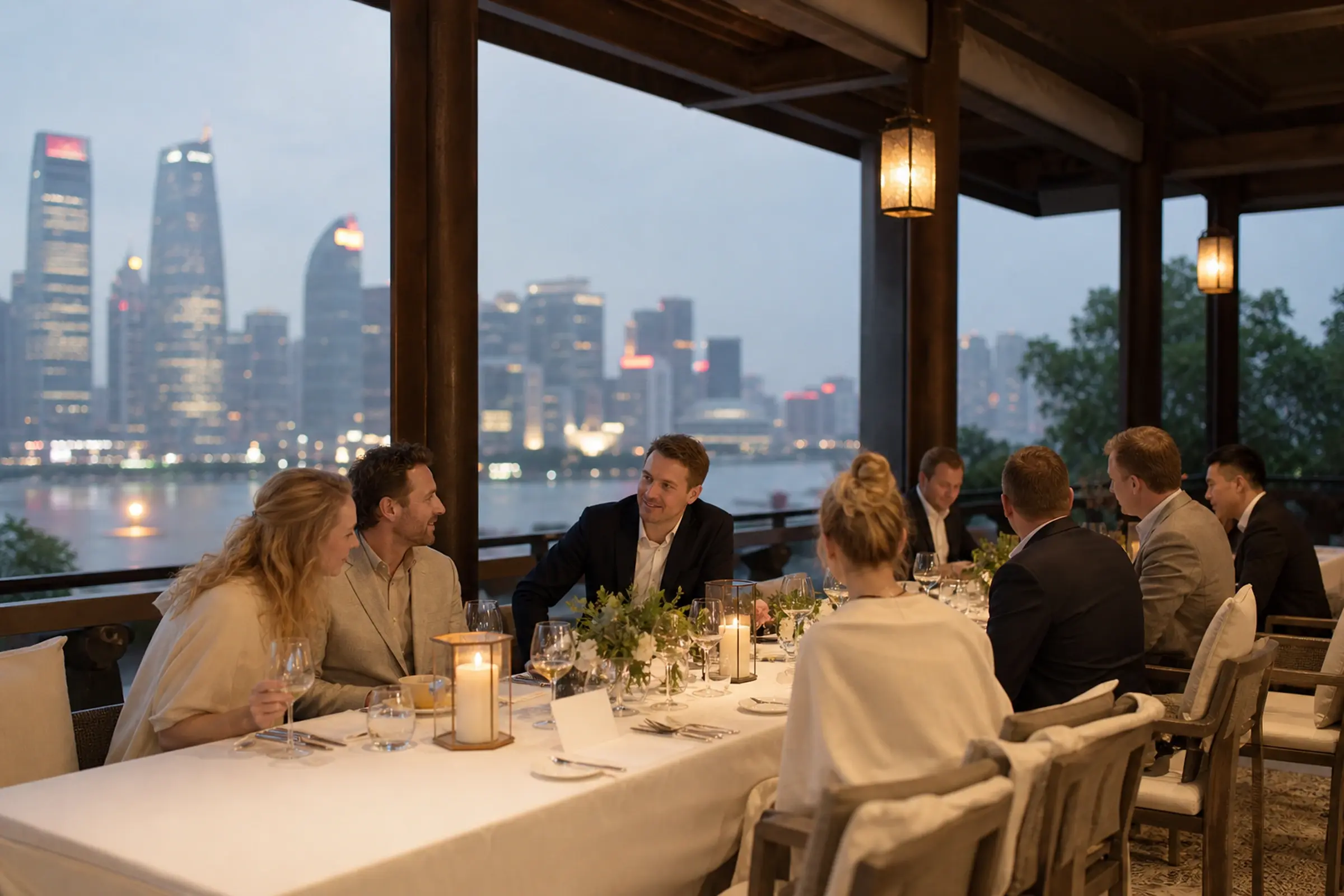A private long-table dinner for a company group on a terrace at dusk